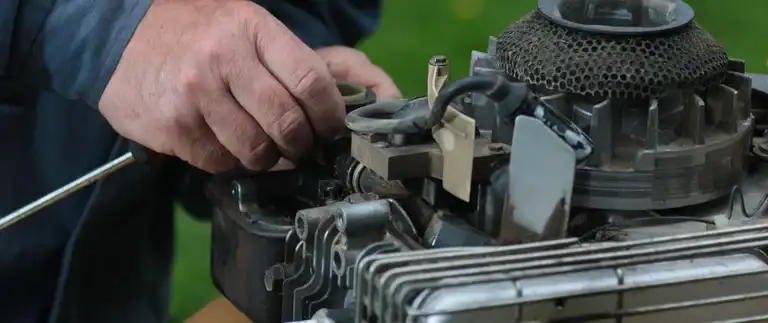 Person checking lawn mower engine oil