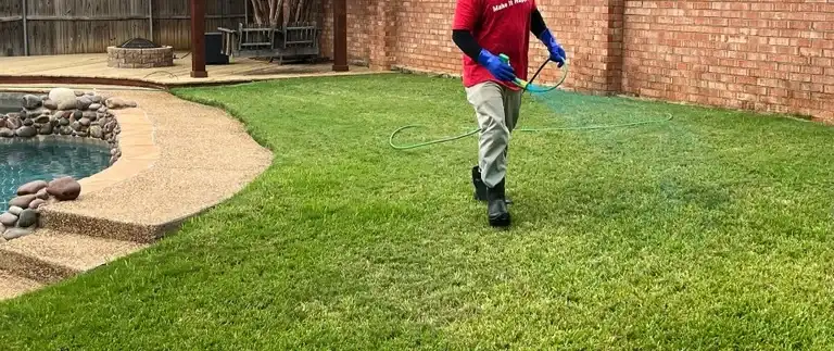 Worker applying pre-emergent weed control to a lawn