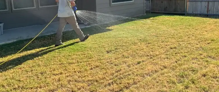 Liquid lawn fertilizer being sprayed on turf