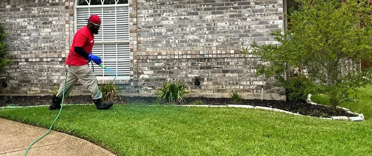 Professional applying liquid fertilizer to a lawn