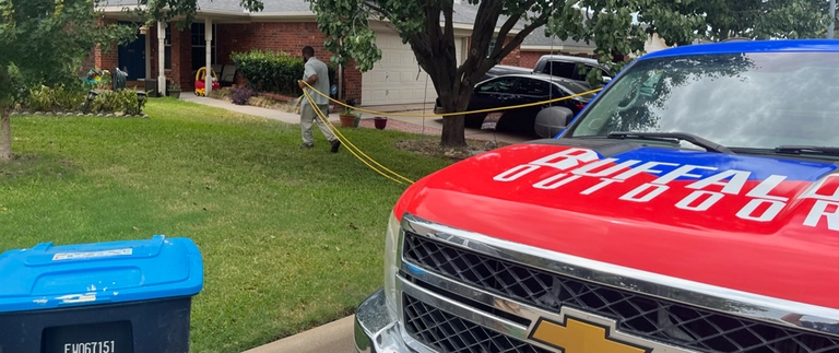 Buffalo Outdoor technician spraying perimeter pest control at a Blue Mound home